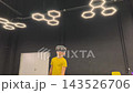 A boy in yellow Tshirt immerses himself in virtual reality. Playing virtual reality game with headset. A party children's center. Modern technology, VR games, and digital entertainment for children. 143526706