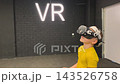A boy in yellow Tshirt immerses himself in virtual reality. Playing virtual reality game with headset. A party children's center. Modern technology, VR games, and digital entertainment for children. 143526758