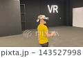A boy in yellow Tshirt immerses himself in virtual reality. Playing virtual reality game with headset. A party children's center. Modern technology, VR games, and digital entertainment for children. 143527998