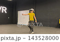 A boy in yellow Tshirt immerses himself in virtual reality. Playing virtual reality game with headset. A party children's center. Modern technology, VR games, and digital entertainment for children. 143528000