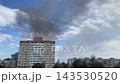 Black smoke rising over burning city 143530520