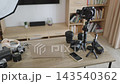 A collection of professional photography and videography equipment is neatly arranged on a wooden desk, ready for content creation 143540362