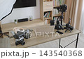 A collection of cameras, lenses, lighting, and accessories arranged on a desk for content creation 143540368
