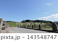 A rural landscape with rolling hills and a vast blue sky visible from the bridge. 143548747