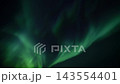 Green aurora borealis ribbons sweeping and twisting across deep night sky in dynamic celestial display, translucent luminous bands flowing and glowing over dark starfield 143554401