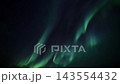 Northern lights aurora borealis ribbons of green light sweeping across starry night sky creating flowing celestial motion and luminous curtains over dark horizon view from ground level nightscape 143554432