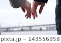 Close up of couple reaching hands toward each other with wedding rings by river 143556958