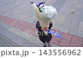Smiling child holding a large colorful flower bouquet outdoors in the city 143556962