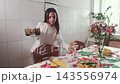 Girl serving drinks for a family celebration at home. Hospitality, care for loved ones and holiday mood. 143556974
