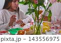 Teenage girl tasting holiday treats at a festive table. Simple joys, family celebration and carefree youth. 143556975
