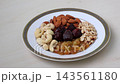 Assorted Mixed Dry Fruits and Nuts on Ceramic Plate - Almonds, Cashews, Raisins, Peanuts, and Dates Healthy Snack Concept Assorted Mixed Dry Fruits and Nuts on Ceramic Plate - Almonds, Cashews, Raisins, Peanuts, and Dates Healthy Snack Concept 143561180