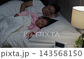 mother and daughter sleeping together in a bed at night  143568150