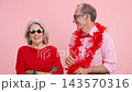 Energetic senior couple playfully preparing themselves on pink background 143570316