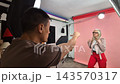 Male photographer directing mature model in a fun studio photoshoot 143570317