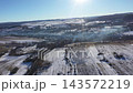 Flying over a village in wintertime, aerial view of smoking chimneys in early morning lights 143572219