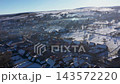 Flying over a village in wintertime, aerial view of smoking chimneys in early morning lights 143572220