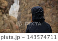 Person in black jacket sitting in falling snow in slow motion  143574711