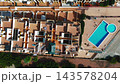 Drone point of view over Mediterranean apartment terraces and an outdoor swimming pool 143578204