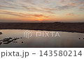 昇る朝日に輝く砂漠湖、テンゲル砂漠の空撮映像 143580214