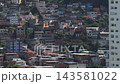 Dense Hillside Housing and Modern Tower in Urban Haze 143581022