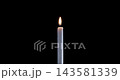 Lit taper candle on a black background. The golden flame of the candle slowly flickers. A minimalist candle for background or over-layer with blending mode screen, lighten, or add. 143581339