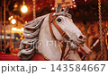 Carousel Horse Rotates On A Merry-Go-Round At The Christmas Fair With Garland Lights 143584667