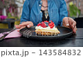 Woman Savoring Belgian Waffles With Whipped Cream And Berries Resting In Cafe With Dessert 143584832
