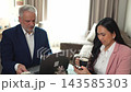 Meeting over coffee with a focused Asian woman and her colleague in a cozy office setting Meeting over coffee with a focused Asian woman and her colleague in a cozy office setting 143585303