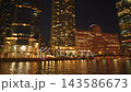 Illuminated skyscrapers and colorful office buildings reflect across the Chicago River at night in downtown Chicago. Modern waterfront architecture and glowing city lights create a vibrant urban 143586673