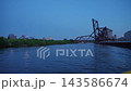 Historic steel lift bridge crossing the Chicago River during blue hour with calm water and distant city lights. Industrial bridge architecture and urban waterfront scenery create a dramatic evening 143586674