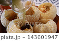 Pouring mint flavored water into traditional Indian panipuri golgappa snack. Pouring mint flavored water into traditional Indian panipuri golgappa snack. 143601947