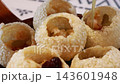 Pouring mint flavored water into traditional Indian panipuri golgappa snack. Pouring mint flavored water into traditional Indian panipuri golgappa snack. 143601948