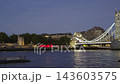Panning shot along the River Thames toward floodlit Tower Bridge during evening blue hour in London 143603575