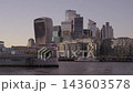 Static medium shot of the City of London financial district skyline at evening twilight with HMS Belfast moored along the River Thames 143603578