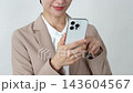 A middle-aged businesswoman using a smartphone; white background; face not visible. 143604567