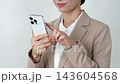A middle-aged businesswoman using a smartphone; white background; face not visible. 143604568