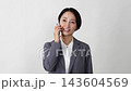 A middle-aged businesswoman making a phone call on her smartphone against a white background. 143604569