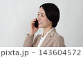A middle-aged businesswoman making a phone call on her smartphone against a white background. 143604572