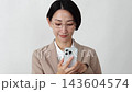 A middle-aged businesswoman using a smartphone; white background. 143604574