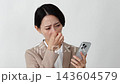 Businesswoman looking at her smartphone; eye strain; white background 143604579