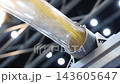 Plastic pneumatic conveying. Golden yellow plastic pellets flowing through transparent industrial tubing. Plastic manufacturing show material transport. Automated processing polymer production tech. 143605647