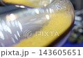 Plastic pneumatic conveying. Golden yellow plastic pellets flowing through transparent industrial tubing. Plastic manufacturing show material transport. Automated processing polymer production tech. 143605651