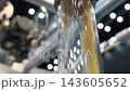 Plastic pneumatic conveying. Golden yellow plastic pellets flowing through transparent industrial tubing. Plastic manufacturing show material transport. Automated processing polymer production tech. 143605652