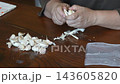 A woman dividing garlic 143605820