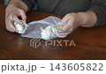 A woman dividing garlic 143605822
