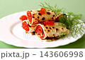 crepes stuffed with red caviar and dill on green background 143606998