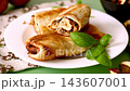 Golden fried pancakes with mushroom filling on white plate 143607001