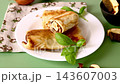 Homemade crepes stuffed with dried mushrooms on green background 143607003