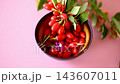 Ripe goji berries with flowers arranged on pink background 143607011