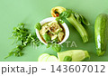 Homemade spicy zucchini with garlic spices on green background 143607012